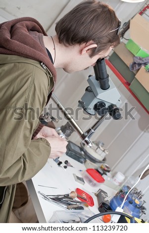 jeweller is working with  microscope at jeweller\'s workshop