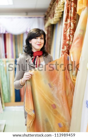 woman  chooses draperies at shop