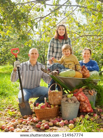 Happy  family with vegetables harvest in garden