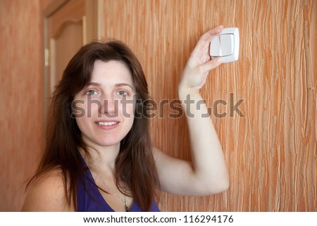 Young woman with light-switch in home - stock photo