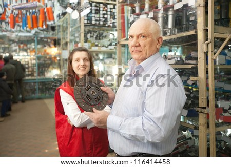 mature man buys engine clutch in auto parts store