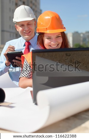 two builders wearing protective helmet works on the building site
