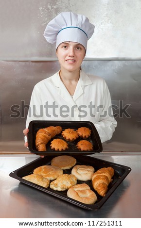 Baker with fresh pastries at bakery