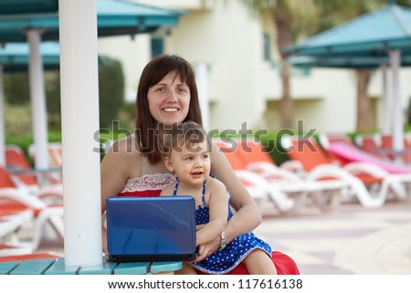 happy mother and  daughter   with notebook   at resort hotel area