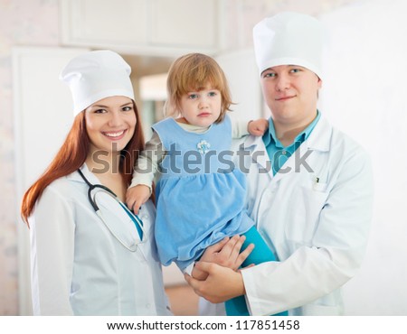 friendly doctors with baby girl in the clinic