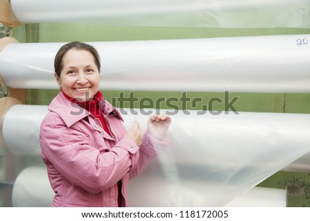 Woman  chooses polythene at foil roll at market