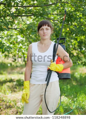 working woman with garden spray  in orchard
