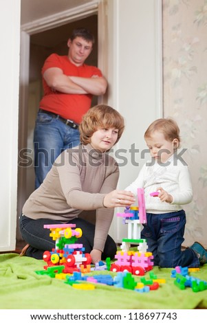 parents and child plays with set in home