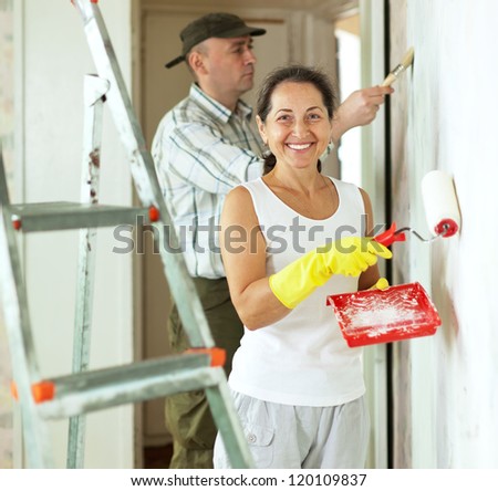 Smiling woman and man makes repairs in home