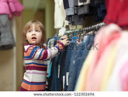 two-year child  chooses jeans at wear shop