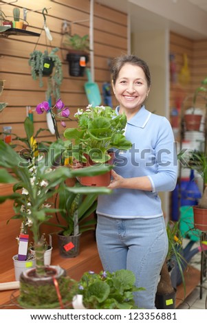 Woman with auricula flower in flower store