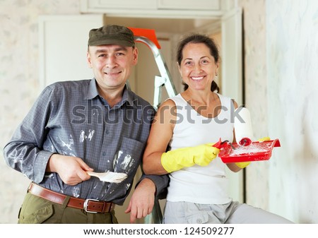 Happy woman and man makes repairs in home interior together