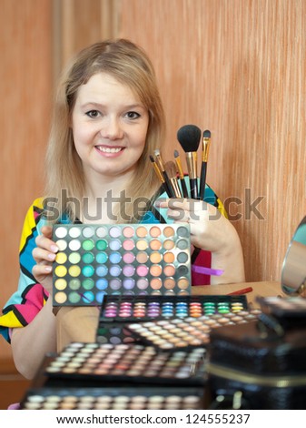 Female visagiste with cosmetics ready for job