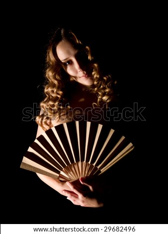 nudity girl with a fan on black. Isolated