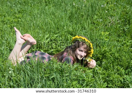 stock photo barefoot teen girl in a chaplet lying from meadow