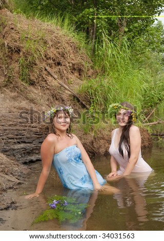 Two girls in  flower wreath  at river