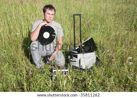 dj man with  vinyl disk and radio at nature