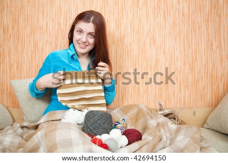 young woman knitting with knitting-needle at home