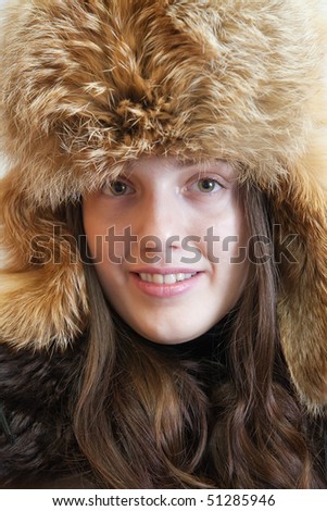Portrait of long haired young woman in  fox hat