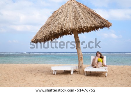 beauty girl relaxing in deck chair at resort beach