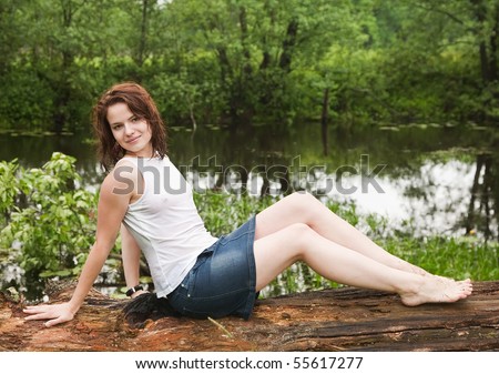girl in wet shirt on old tree during rain