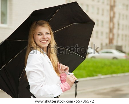 Pretty  girl in cloak with umbrella outdoors