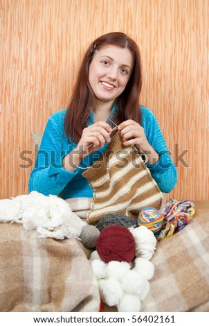 young woman knitting with knitting-needle at home