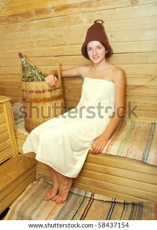 Young woman is taking a steam-bath  at sauna
