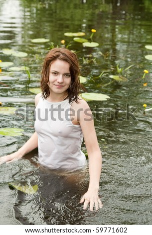 Sexy girl in white wet shirt at lake
