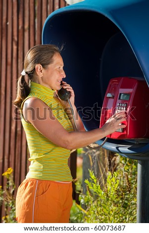 Senior woman  on the pay phone outdoor