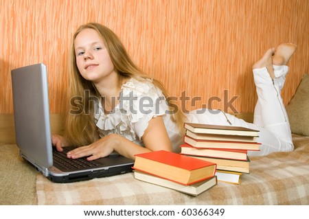 pretty young girl  with laptop and books on sofa