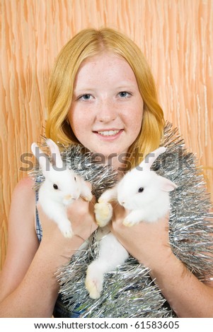 teen girl in peddlery  with two pet rabbits