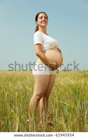 Portrait of 8 months pregnant woman  in rye field