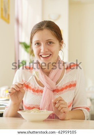 smiling girl  eating dumplings  at lunch counter