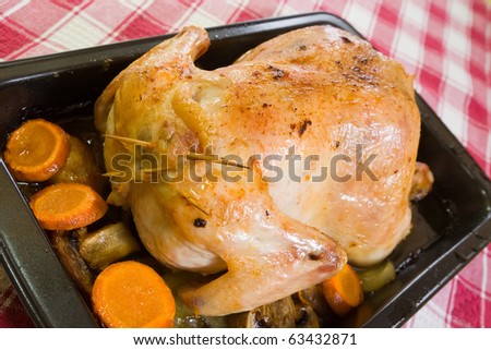 stuffed chicken in roasting pan on checked tablecloth. Last of the stages of preparation of  stuffed chicken.  See series