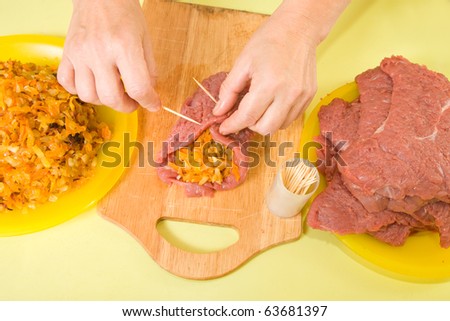 Closeup of cook sewing stuffed beef by toothpicks. One of the stages of preparation of the stuffed beef.  See series