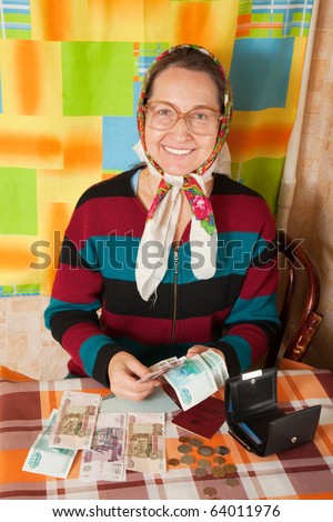 Happy elderly woman with  money at her home