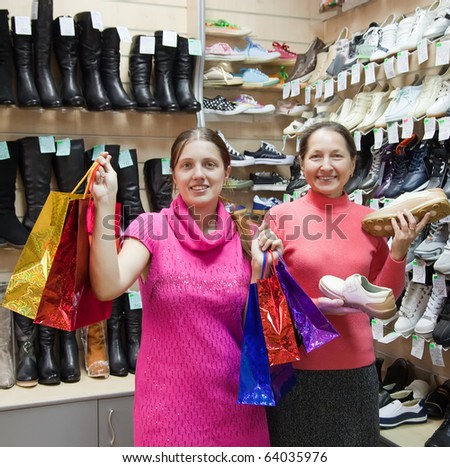Two happy women with shopping bags at  shoes shop