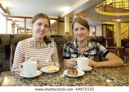 Beautiful girls relaxing at coffee-room with a cup of coffee