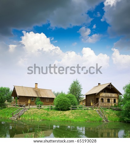 Summer from rural landscape. Wooden house near lake