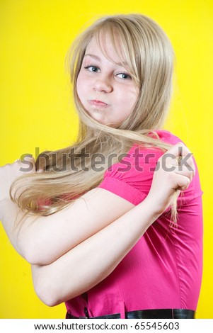 girl puffs up her cheeks over yellow background