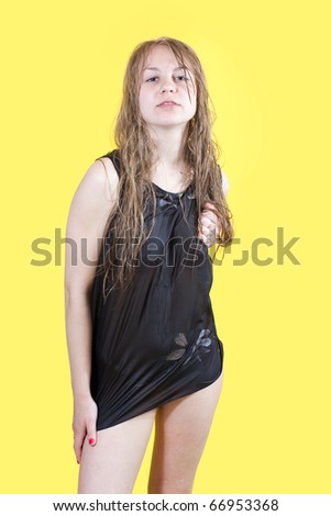 studio shot of sexy girl in wet shirt over yellow