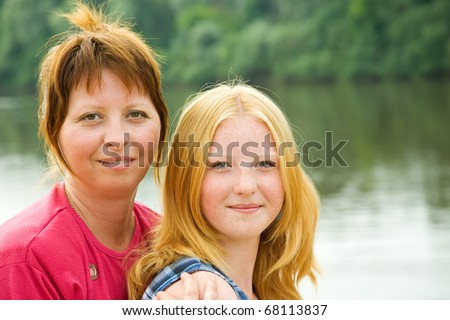 Portrait of mother with teenager daughter against landscape