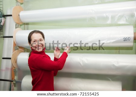 Woman chooses  polythene for hothouse at foil roll in  market