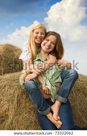 stock photo Country girls play on hay against sky