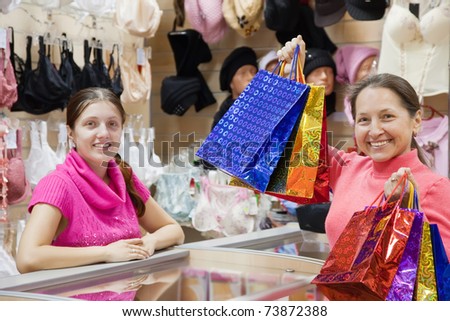 Female mature customer with shopping bags at  counter in   sho