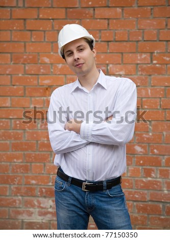 Man in hard hat  against  the brick wall