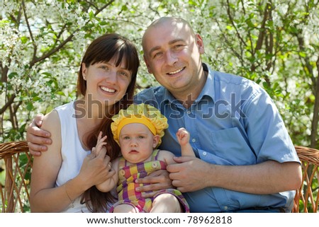 Portrait of happy family against blossoming garden in spring