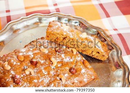 homemade fresh  honey cake with nuts on checked tablecloth. The end of cooking of  honey cake.  See series