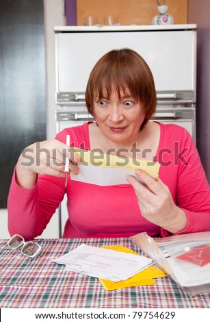mature woman with utility bills at her home